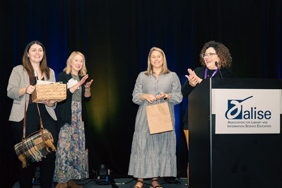 Four women on stage at a professional conference