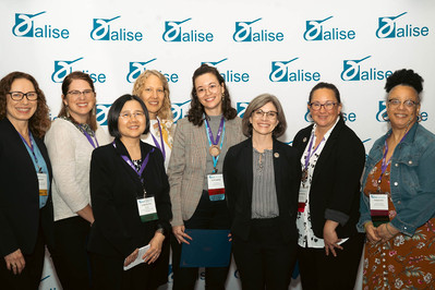 A group of women in front of a step and repeat