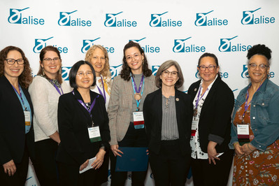 A group of women in front of a step and repeat