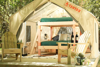Interior design styling for a TENTRR camping campaign showing an outdoor bunk bed and Adirondack chairs.