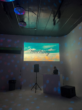 A woman DJing in a photo studio during a DIY party.