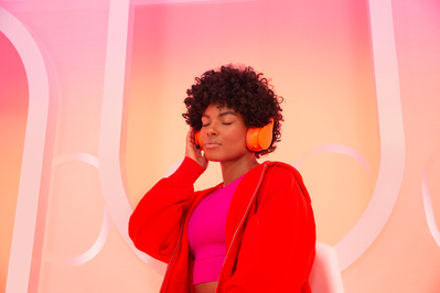 Commercial photography of a black woman using headphones on an airplane.