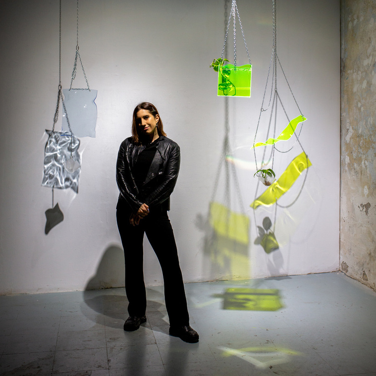 Portrait of Sara Wass, a studio artist, with her handmade colored acrylic sculptures.