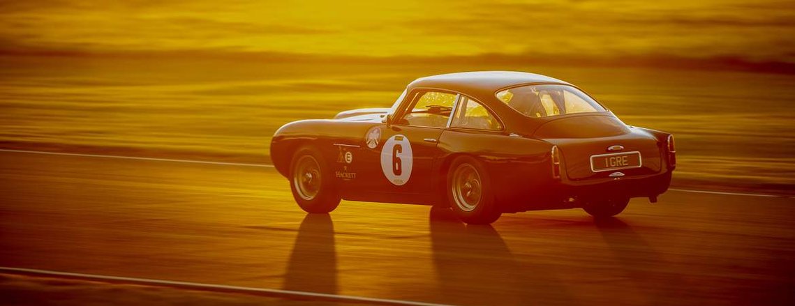 A car racing into the sunset at The Goodwood Revival