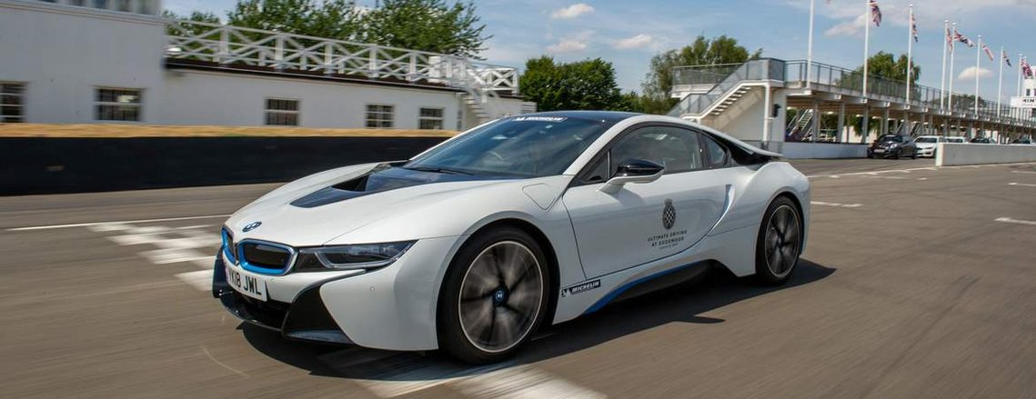 A BMW I8 racing across the finish line at The famous Goodwood Motor Circuit 