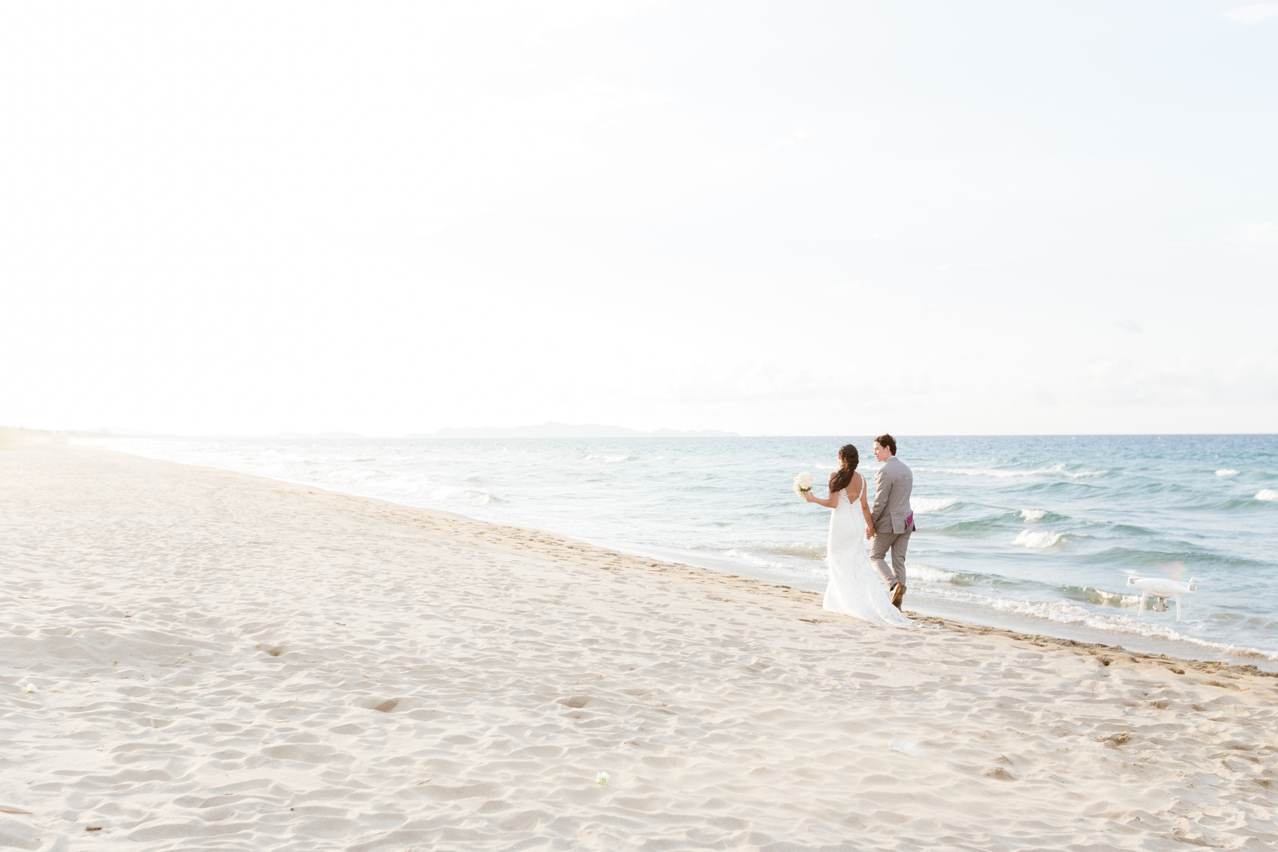 Newlywed couple walking near the shore. Beach Destination Wedding Photography. 