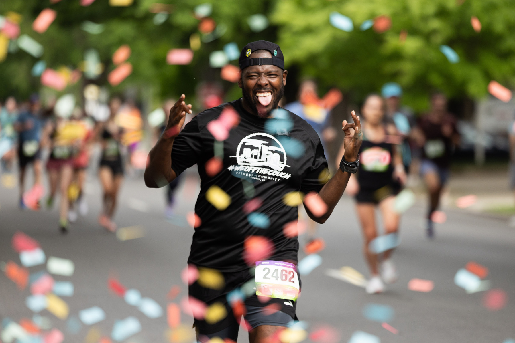 Anthony Clary gestures as he runs through confetti during the Ukrop's Monument Avenue 10k in Richmond Va., Saturday, April 22, 2023.
