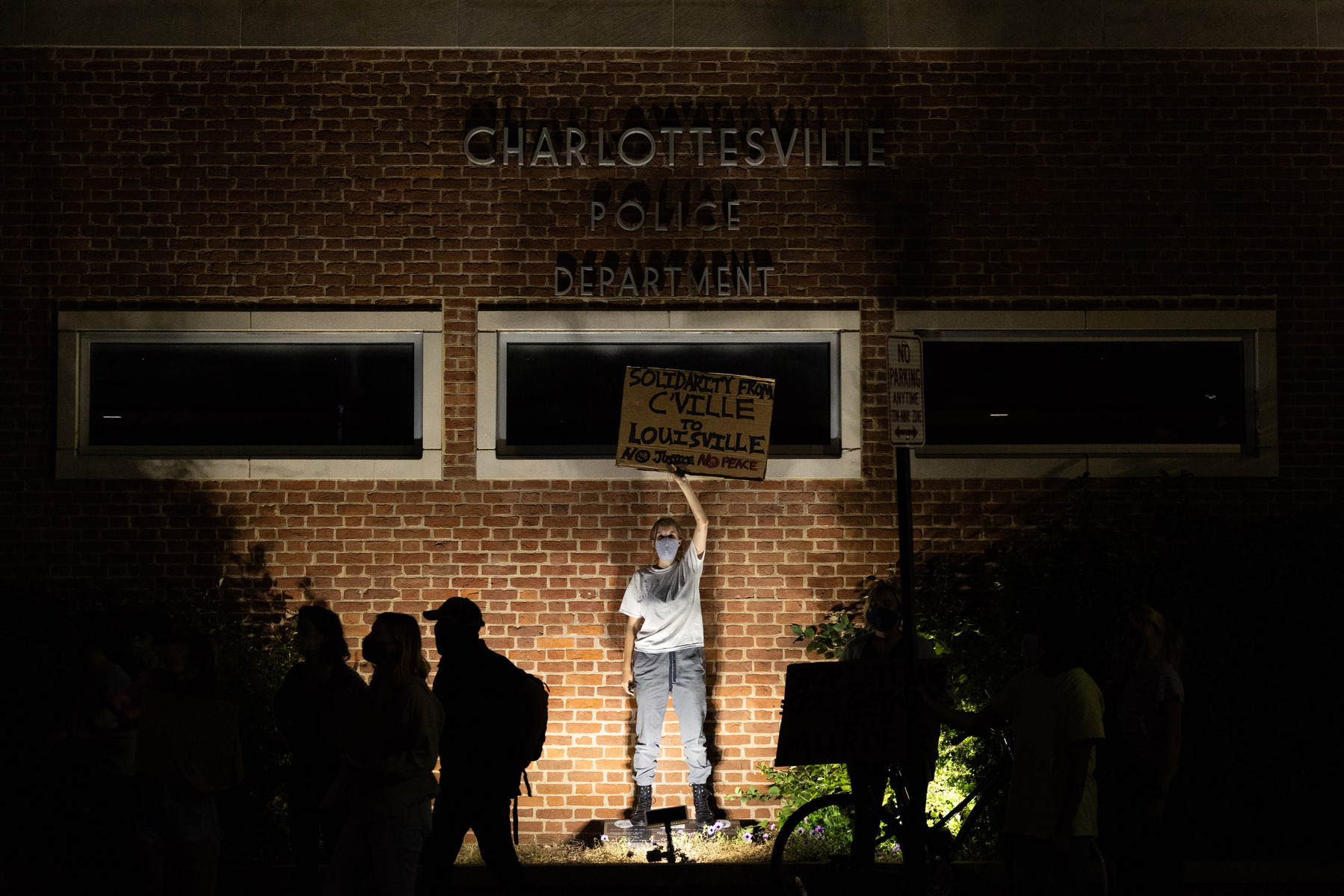 A demonstrator holds up a sign in front of the Charlottesville Police Station during a Black Lives Matter march in Charlottesville, Va., on Wednesday, Sept. 23, 2020.