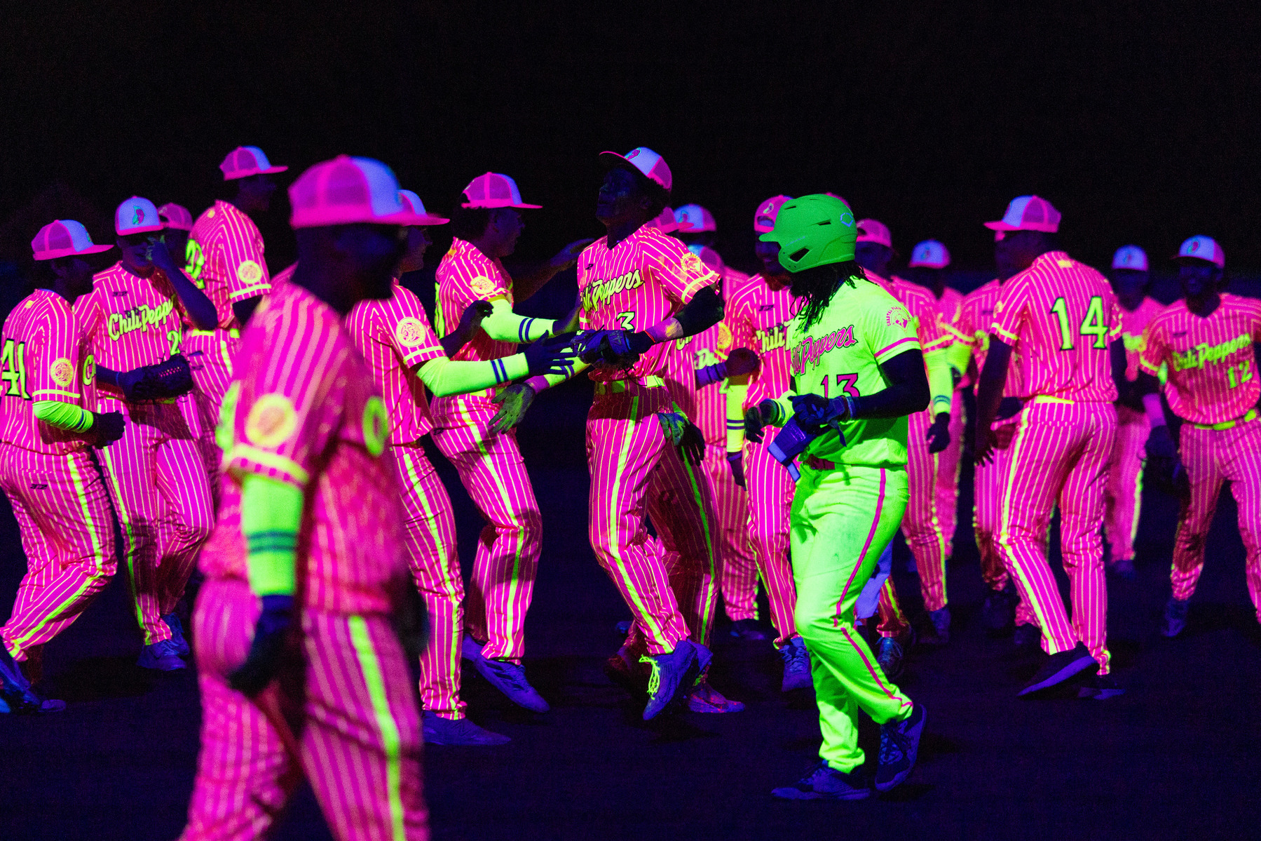 The Tri-City Chili Peppers celebrate after a 9-4 win over the Greenbrier Knights in what the team is calling the first-ever game of "Cosmic Baseball," in Colonial Heights, Va., Saturday, June 1, 2024.
