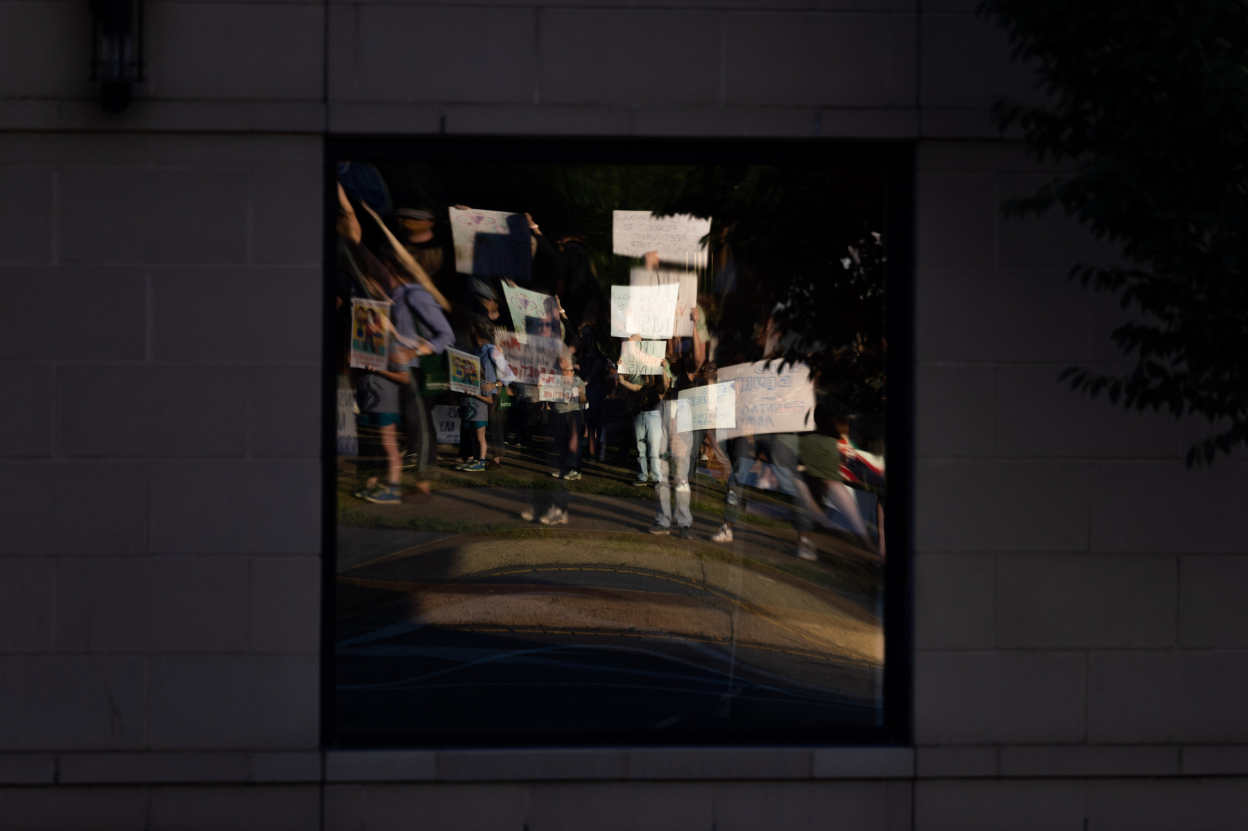 An abortion rights demonstration in front of the Federal Building and U.S. Courthouse is reflected in a window in Charlottesville, Va., on Friday, June 24, 2022.