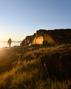 Adventure camp spot with tent lit by the midnight sun in Greenland – Stand up paddling adventure.