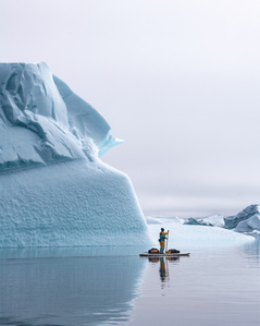 SUP passing by in front of  iceberg wall during a stand up paddling expedition – Stand up paddling expedition.