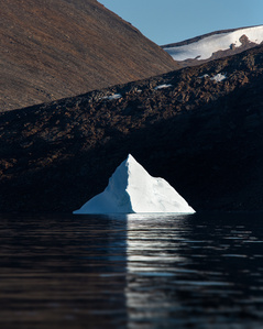 Iceberg under the light of the midnight sun in Greenland – Stand up paddling adventure.