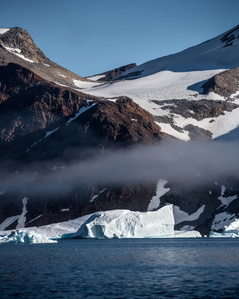 Iceberg in front of mountains in Greenland – Stand up paddling adventure.