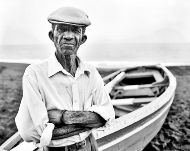 Travel photography Switzerland – Manuel standing proud in front of his fishing boat on the beach of São Filipe, Cape Verde.