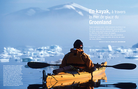 Publication tearsheet of a sea kayaker with a sea full of icebergs and a big mountain covered with snow in the background in north Greenland.