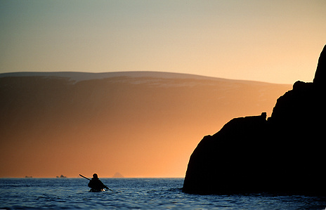 Outdoor photographer Switzerland – paddling under the light of the midnight sun in northwest greenland.