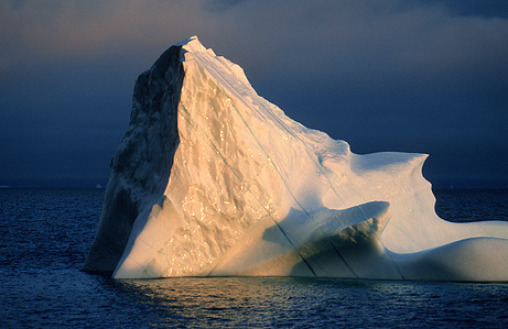 Lone iceberg standing under the midnight sun.