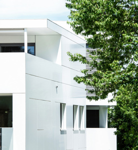 Architecture photography of white building in Einsiedeln using trees in the foreground, Switzerland.