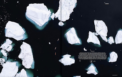 Publication tearsheet of a drone shot from above showing three stand up paddlers paddling in a labyrinth of icebergs in north Greenland.