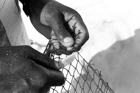 Travel photographer Switzerland – Fisherman in Cabo Verde reparing his net.
