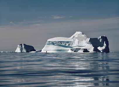 Stand up paddle in front of huge iceberg during an expedition in north west Greenland – Stand up paddling expedition.