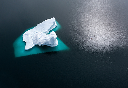 Stand up paddlers paddling next to huge iceberg in Greenland on a SUP adventure – Stand up paddling adventure.