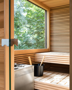 Interior of an outdoor sauna with a window toward a forest.