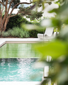Outside pool surrounded by green trees.