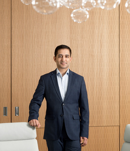 Half body portrait of employee standing in front of wooden wall by Zurich photographer J-L Grossmann