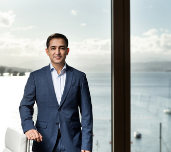 Employee standing in front of window with lake Zurich in the back. Portrait series for Scor a reinsurance company based in Zurich, Switzerland photographed by photographer in Zurich.