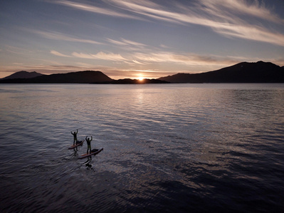 Two lonely stand up paddlers paddling out in the norwegian sea - Adventure photography Switzerland