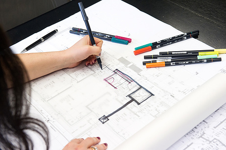 Person sketching on a plan.
