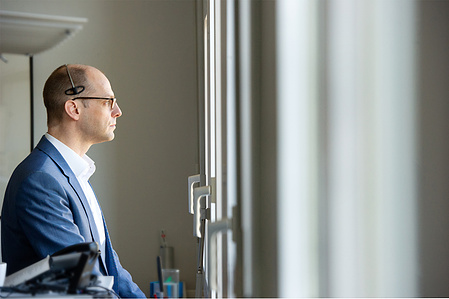 Person in office looking out of the window.