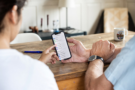Person explaining how a mobile works to a senior.