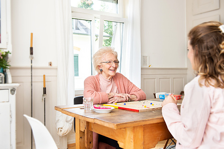 Two person playing at the living room table.