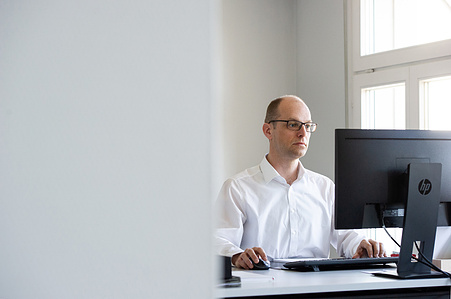 Person in front of the computer in his office.