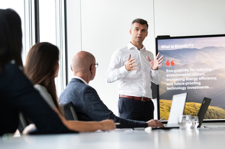 Meeting situation with one person presenting in front of display in Zurich.