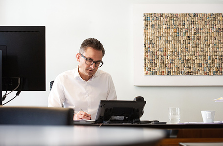 Editorial style photograph of employee sitting at his desk.