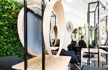 Interior of hairdresser salon with plants in foreground.
