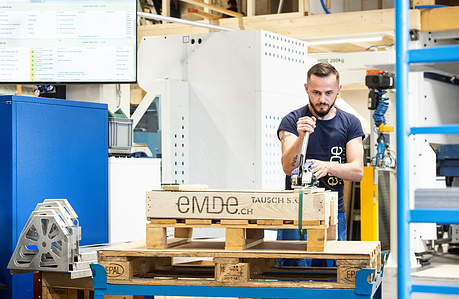 Industrial shot of employee working in factory hall.