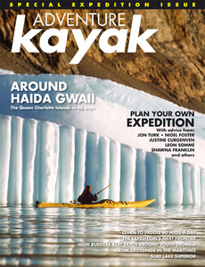 Publication tearsheet of a magazine cover showing a kayaker in front of a structured iceberg wall under the light of the midnight sun in Greenland.
