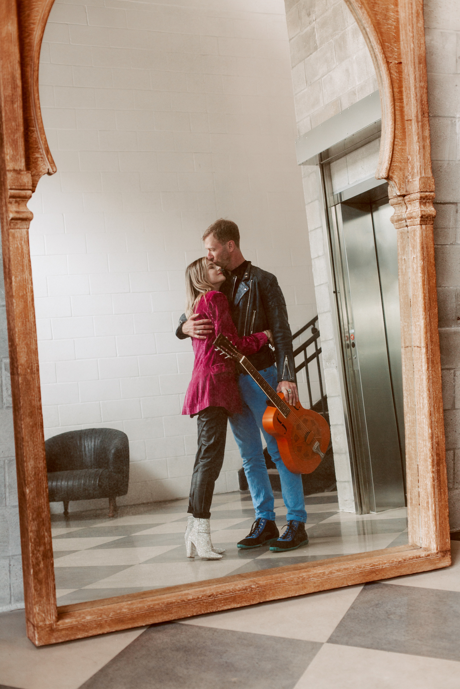 Cinematic moment of a couple with a guitar reflected in a mirror