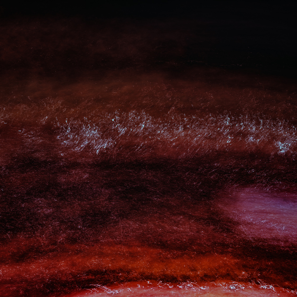 Abstract art of reds of different hues with some splashes of white.