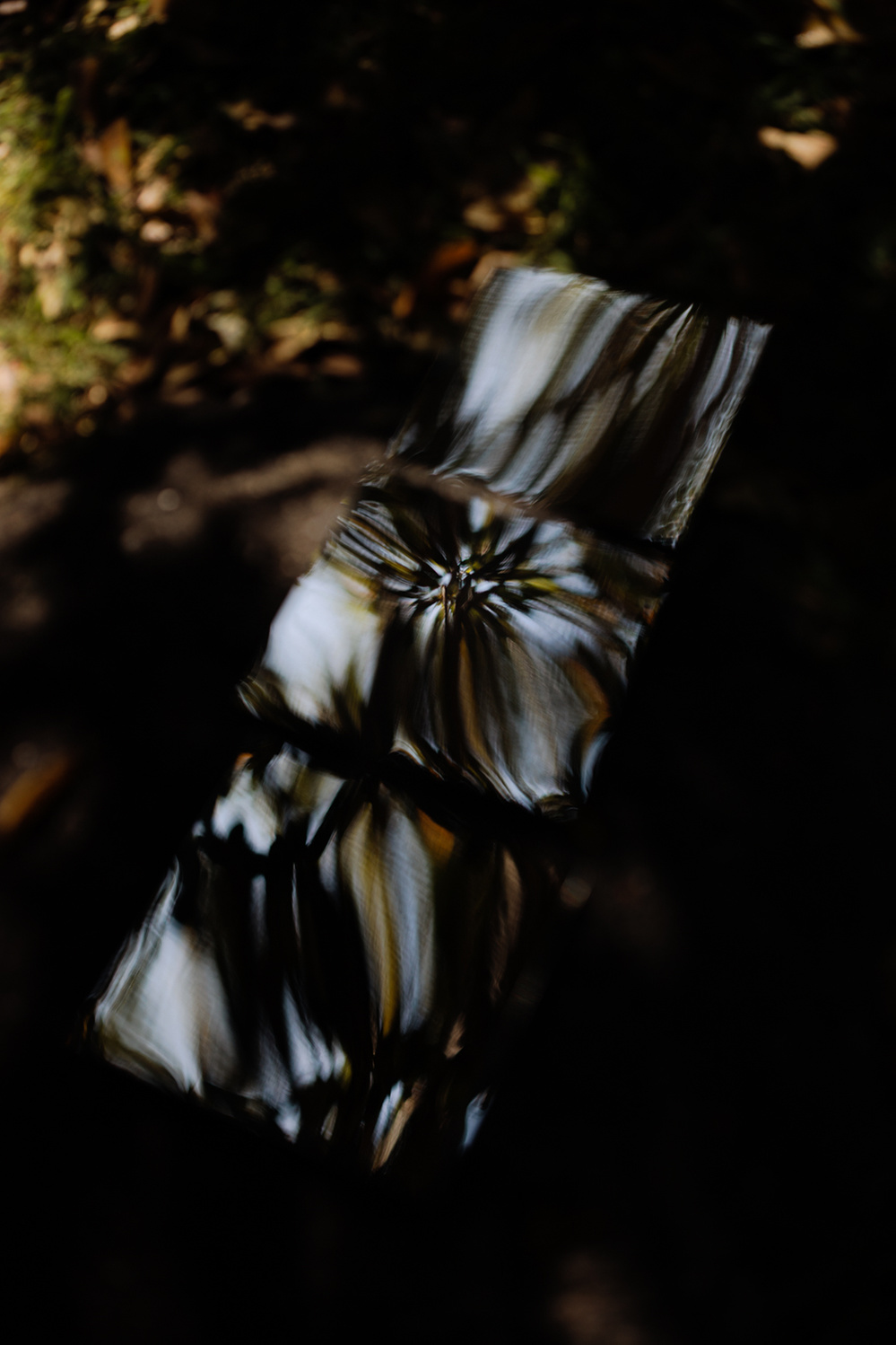 Colour photograph of reflective mirror tiles outdoors showing reflected patterns.