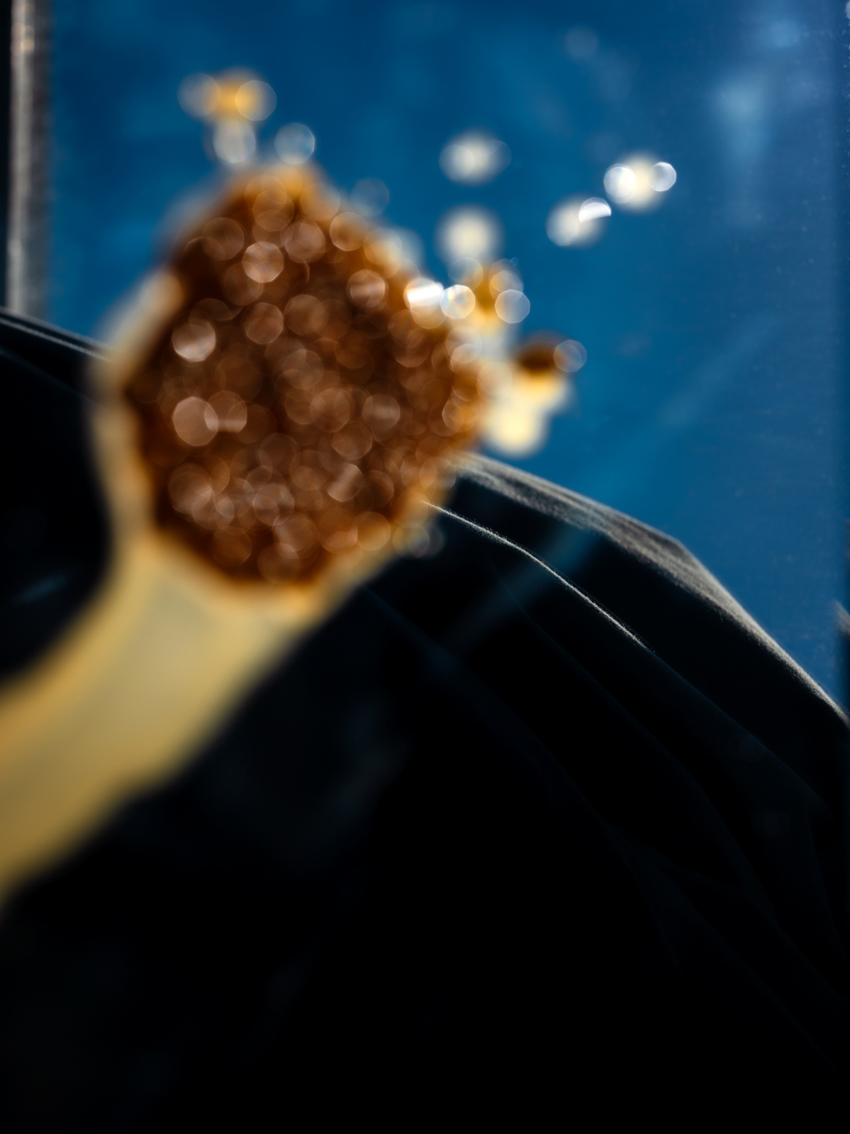 Photograph of blue sky reflected in a mirror with fruit juices trickling down it