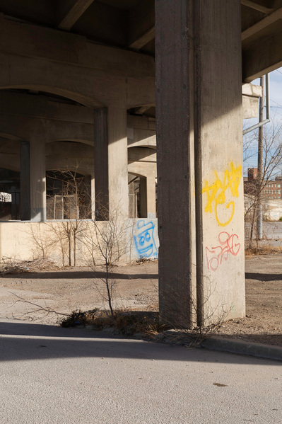 Graffiti on concrete architecture beneath an overpass.