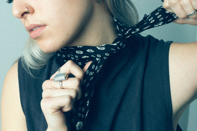 Editorial fashion model in a navy tank dress ties a navy bandana with a white flower pattern around her neck.