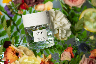 Ouai fragrance product photo on top of a mix of fresh flowers and citrus.