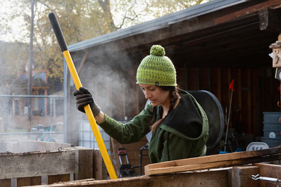 Lifestyle model turns compost with shovel.
